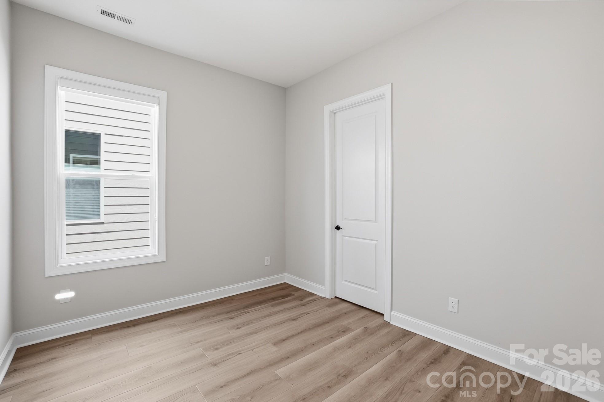 1035 Rabbit Hl Lane Monroe, NC 28110 - Photo 24 of 39 a view of an empty room with wooden floor and a window