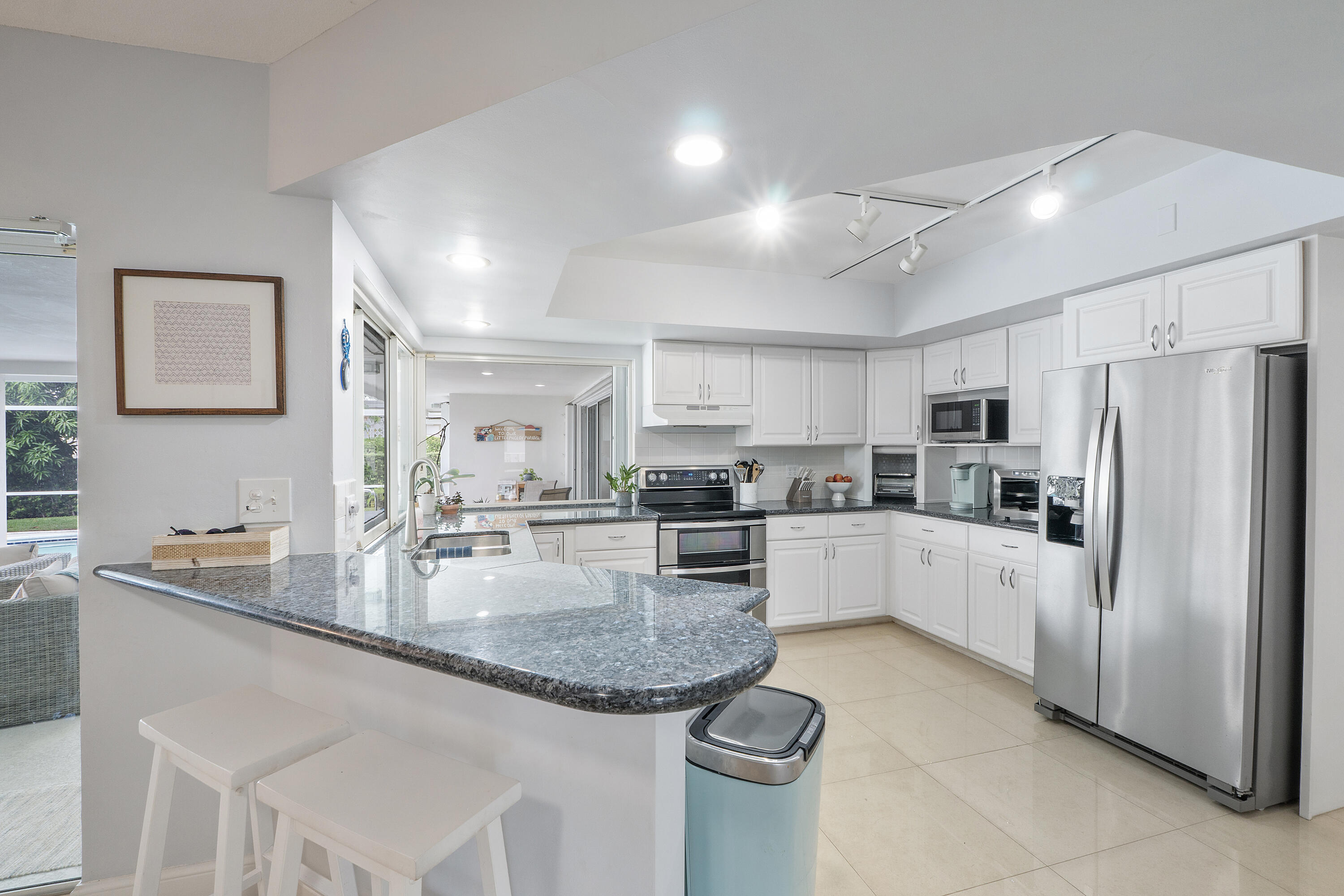 772 Apple Tree Lane Boca Raton, FL 33486 - Photo 12 of 39 a large kitchen with kitchen island white cabinets and stainless steel appliances