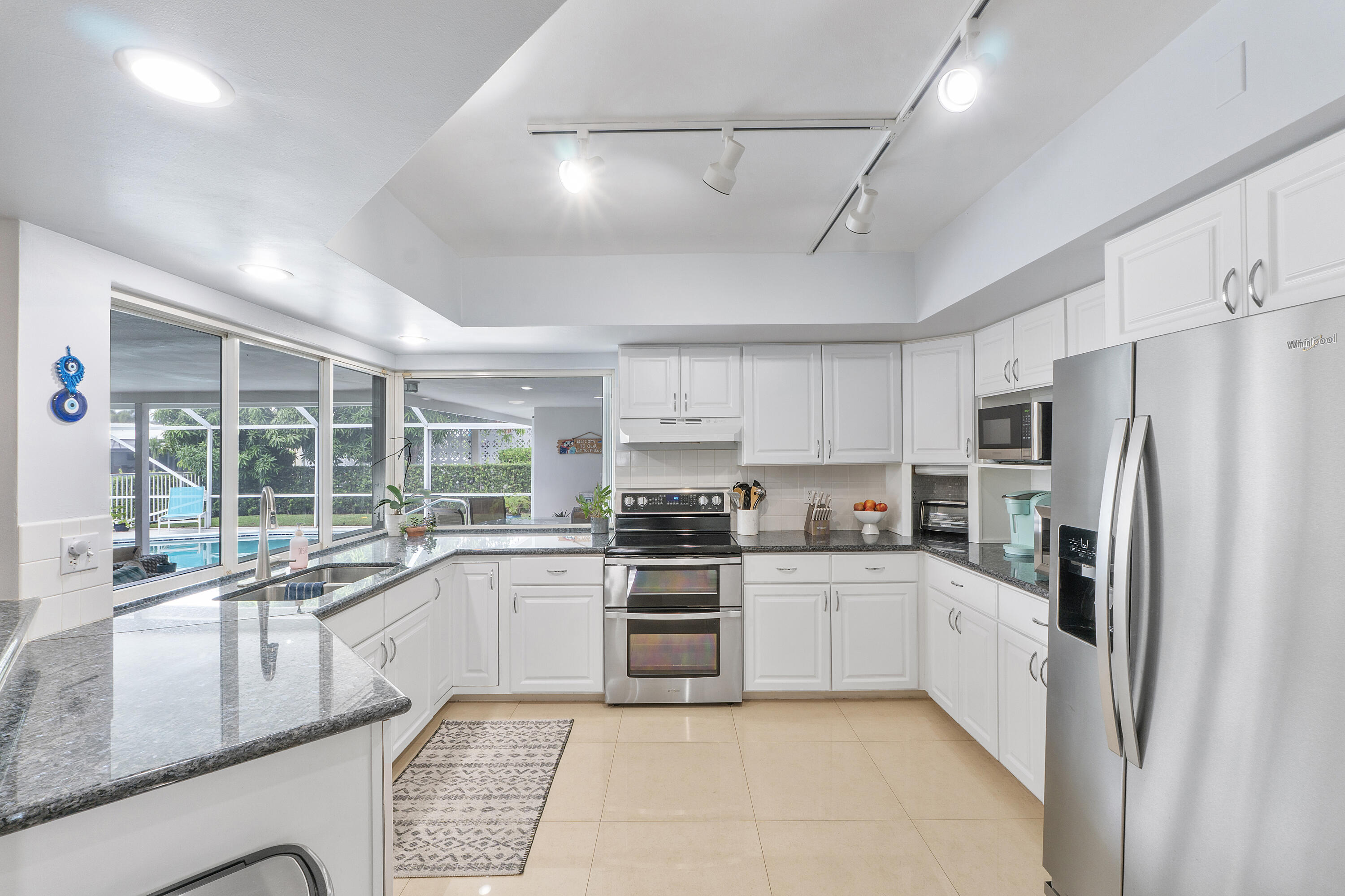 772 Apple Tree Lane Boca Raton, FL 33486 - Photo 13 of 39 a kitchen with white cabinets and stainless steel appliances