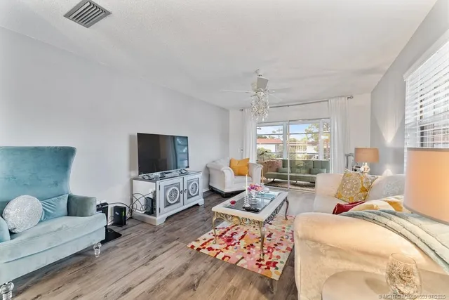 a living room with furniture a flat screen tv and a large window
