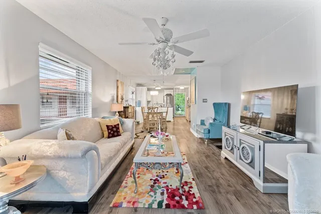 a living room with furniture flat screen tv and a large window