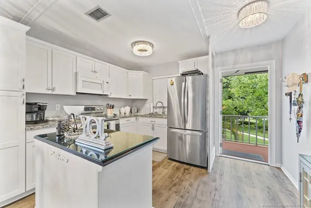 a kitchen with refrigerator cabinets and wooden floor
