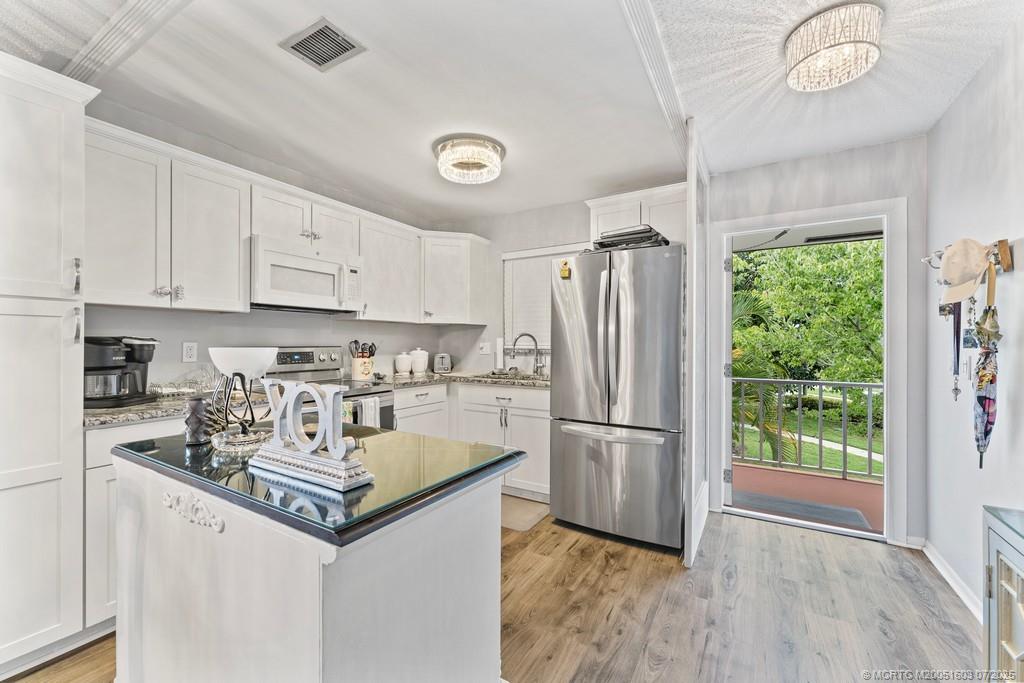 2600 Southeast Ocean Boulevard, Unit FF14 Stuart, FL 34996 - Photo 5 of 26 a kitchen with refrigerator cabinets and wooden floor