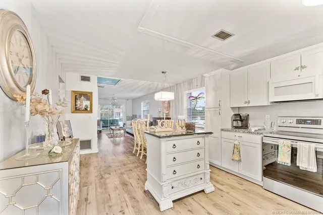 a kitchen with stainless steel appliances kitchen island granite countertop a stove and cabinets