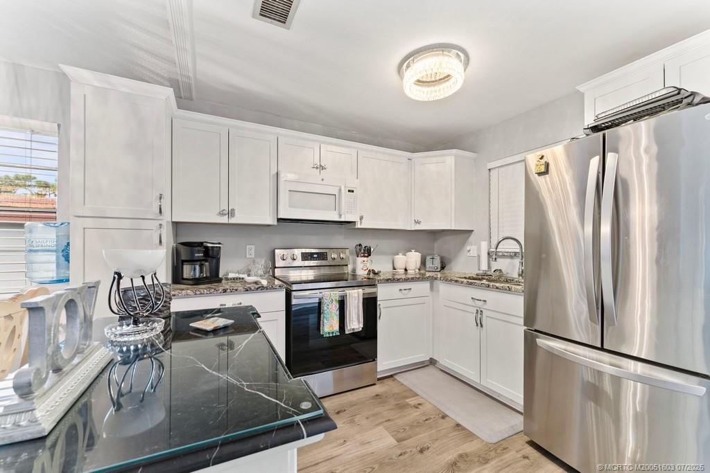 2600 Southeast Ocean Boulevard, Unit FF14 Stuart, FL 34996 - Photo 8 of 26 a kitchen with granite countertop a refrigerator stove top oven and sink