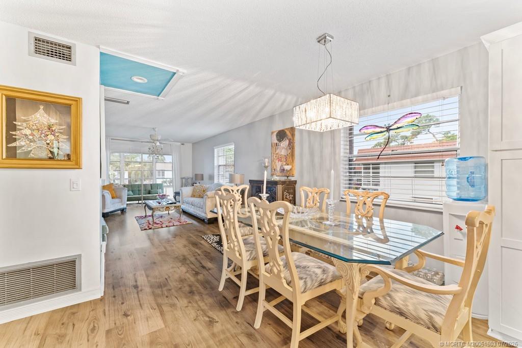 2600 Southeast Ocean Boulevard, Unit FF14 Stuart, FL 34996 - Photo 9 of 26 a view of a dining room with furniture wooden floor and a chandelier