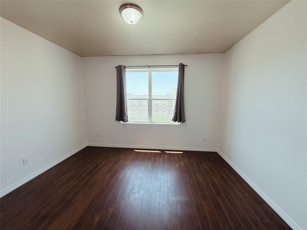 1100 West Trinity Mills Road, Unit 4042 Carrollton, TX 75006 - Photo 12 of 19 Unfurnished room featuring dark wood finished floors and baseboards