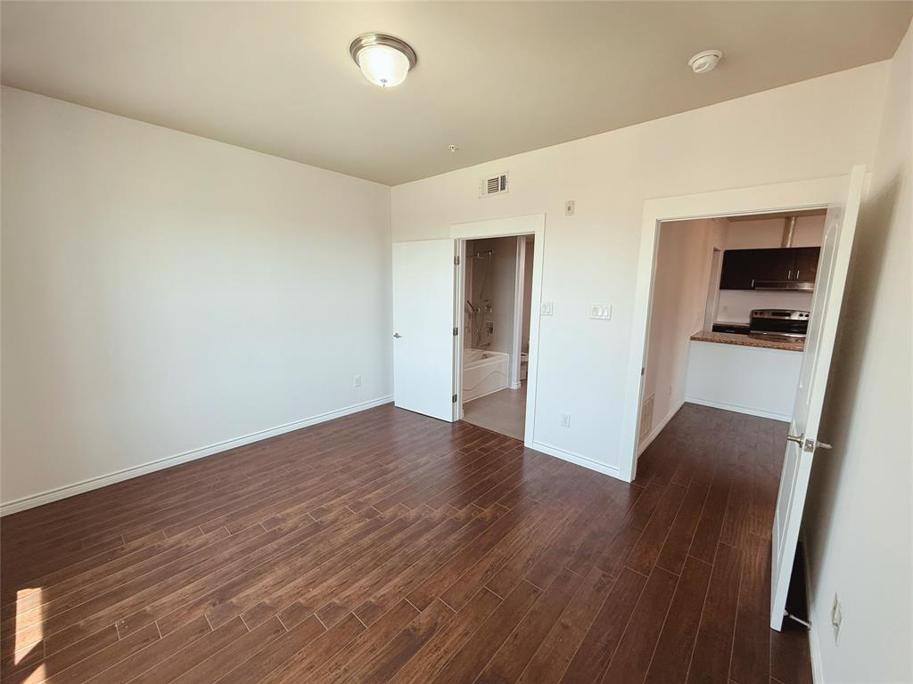 1100 West Trinity Mills Road, Unit 4042 Carrollton, TX 75006 - Photo 13 of 19 Spare room featuring a smoke detector and dark wood-type flooring