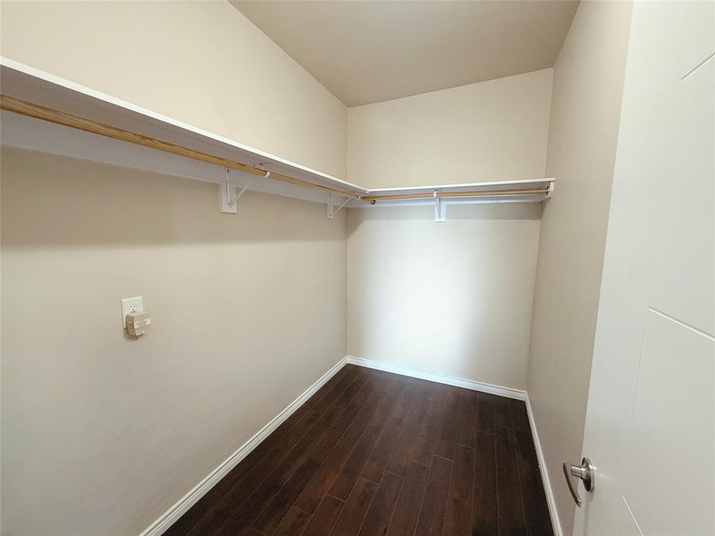 1100 West Trinity Mills Road, Unit 4042 Carrollton, TX 75006 - Photo 16 of 19 Spacious closet featuring dark wood finished floors