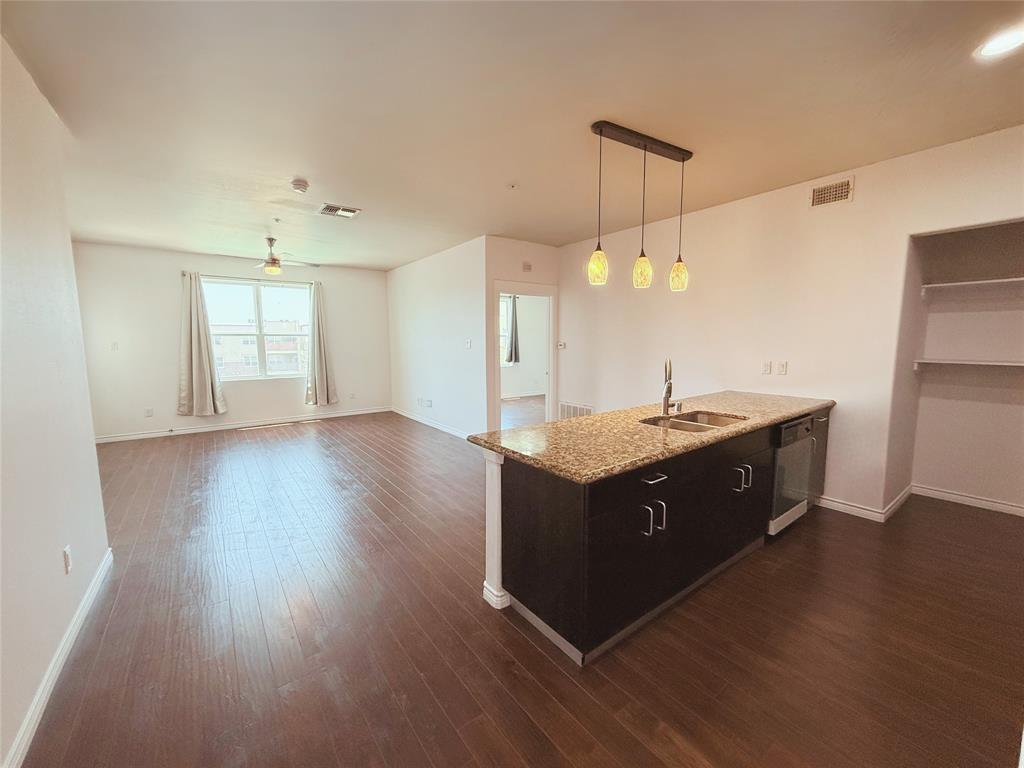 1100 West Trinity Mills Road, Unit 4042 Carrollton, TX 75006 - Photo 2 of 19 Kitchen featuring dishwashing machine, dark wood-type flooring, light stone counters, and pendant lighting