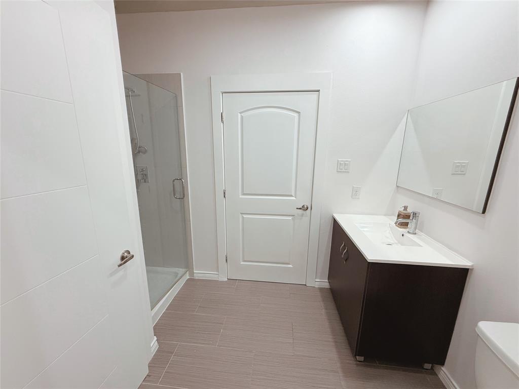 1100 West Trinity Mills Road, Unit 4042 Carrollton, TX 75006 - Photo 6 of 19 Bathroom with vanity, a stall shower, and tile patterned flooring