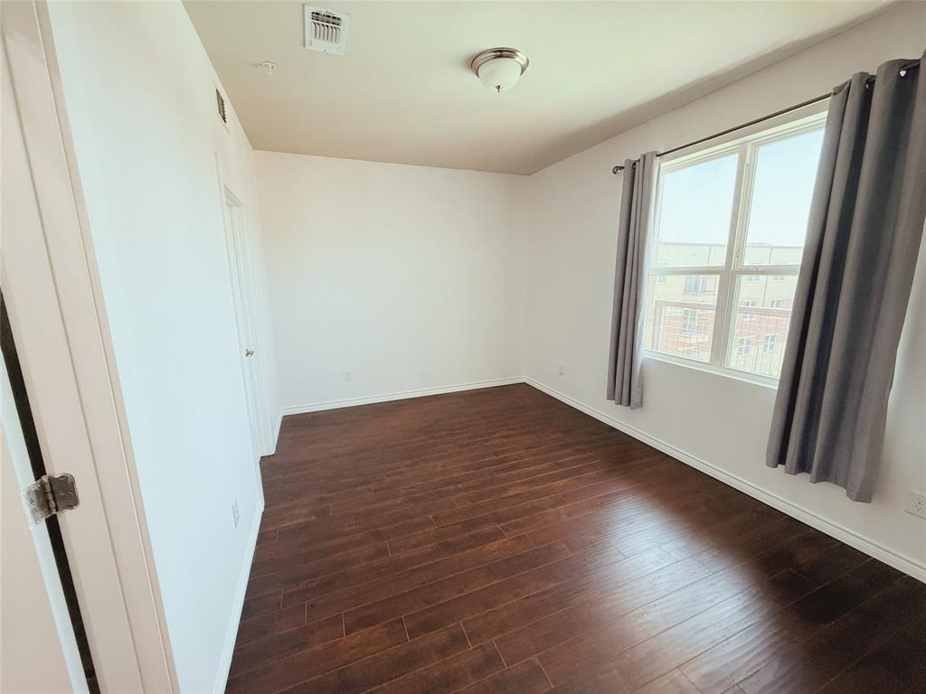 1100 West Trinity Mills Road, Unit 4042 Carrollton, TX 75006 - Photo 7 of 19 Bedroom with dark wood-style floors and baseboards