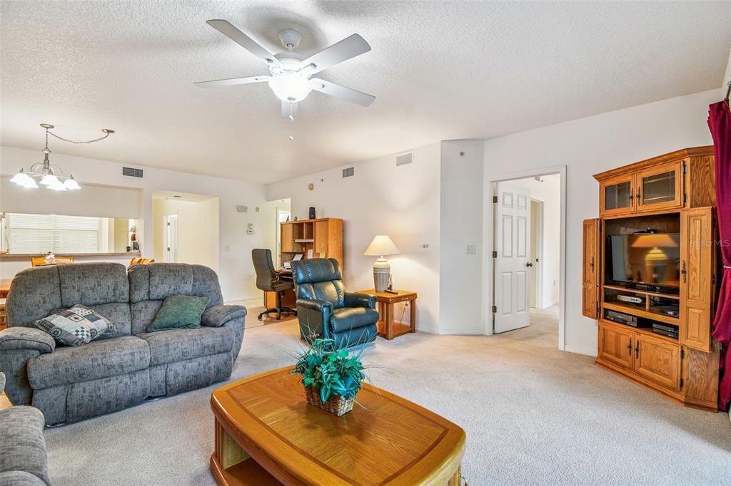 960 Starkey Road, Unit 2203 Largo, FL 33771 - Photo 13 of 53 a living room with furniture and a chandelier