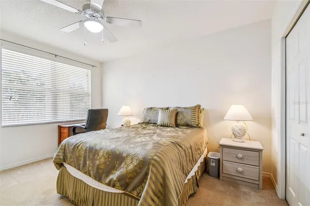 a bedroom with a large bed and a ceiling fan