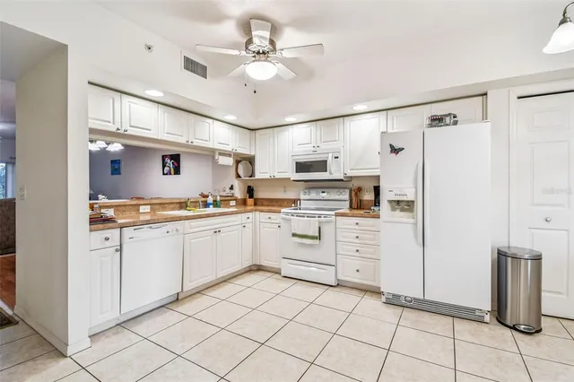 a kitchen with white cabinets and white appliances