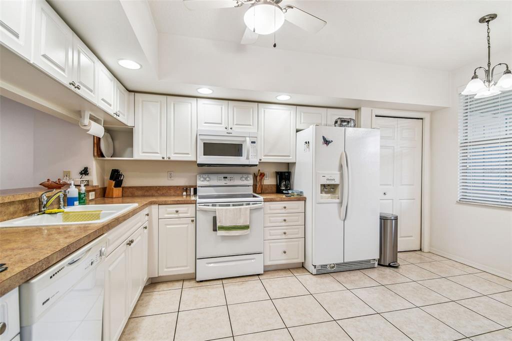 960 Starkey Road, Unit 2203 Largo, FL 33771 - Photo 8 of 53 a kitchen with white cabinets and white appliances