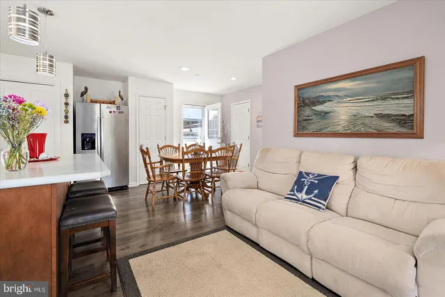 a living room with furniture and a dining table with kitchen countertops