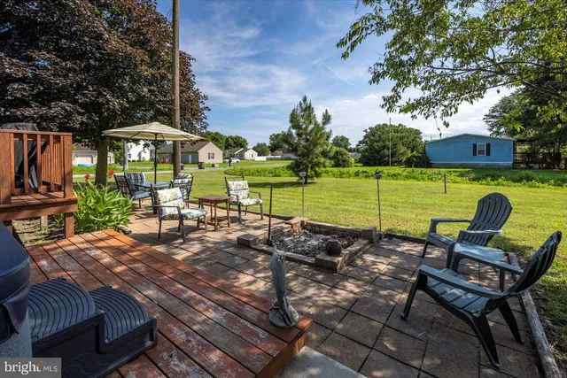 a front view of house with yard and trees in the background