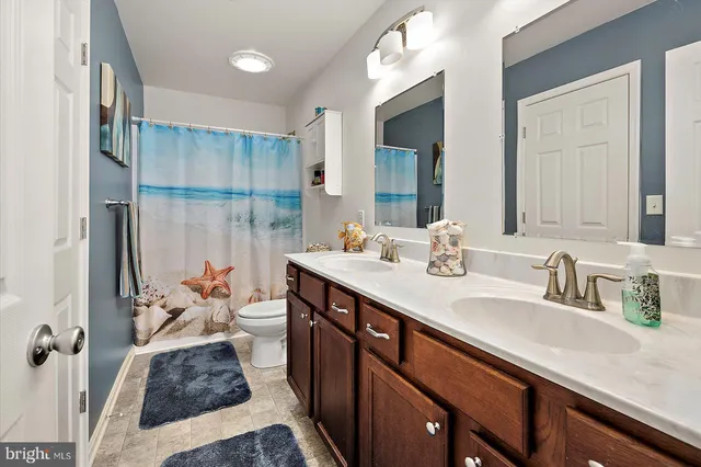 a living room with furniture and a dining table with rug