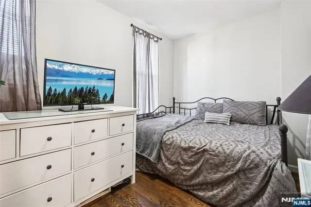 a bedroom with a bed and a mirror on dresser