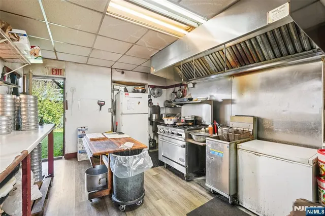 a kitchen with refrigerator and chairs