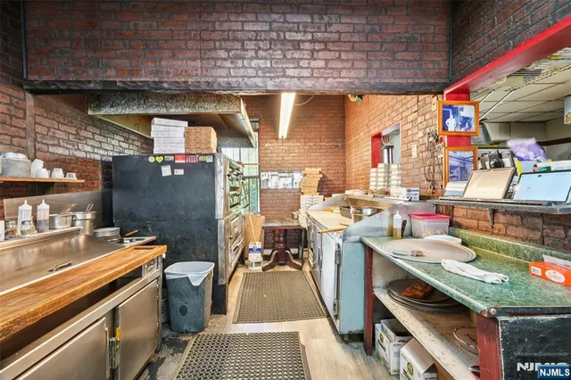 a storage room with stainless steel appliances and wooden floor