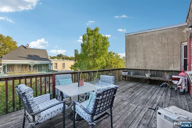 a balcony with wooden floor table and chairs