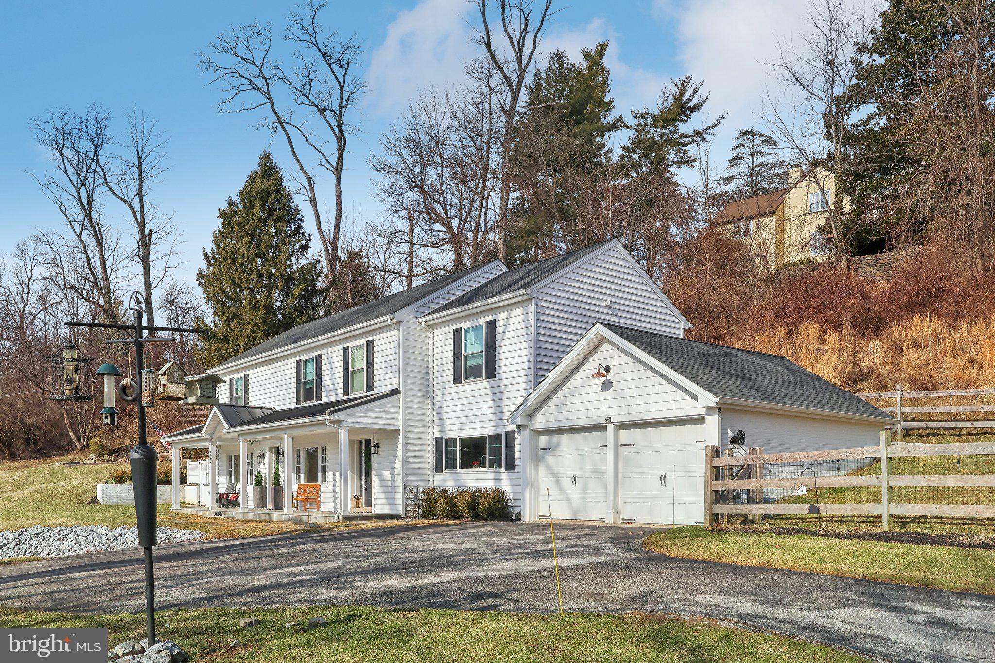 206 Upper Gulph Road Radnor, PA 19087 - Photo 34 of 36 a view of a white house with a large tree and plants next to a yard