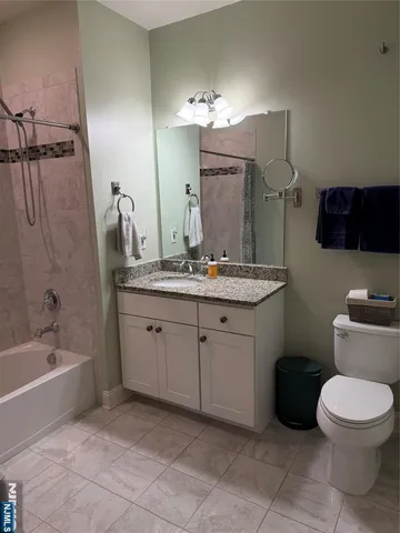 a bathroom with a granite countertop sink a toilet and a bathtub