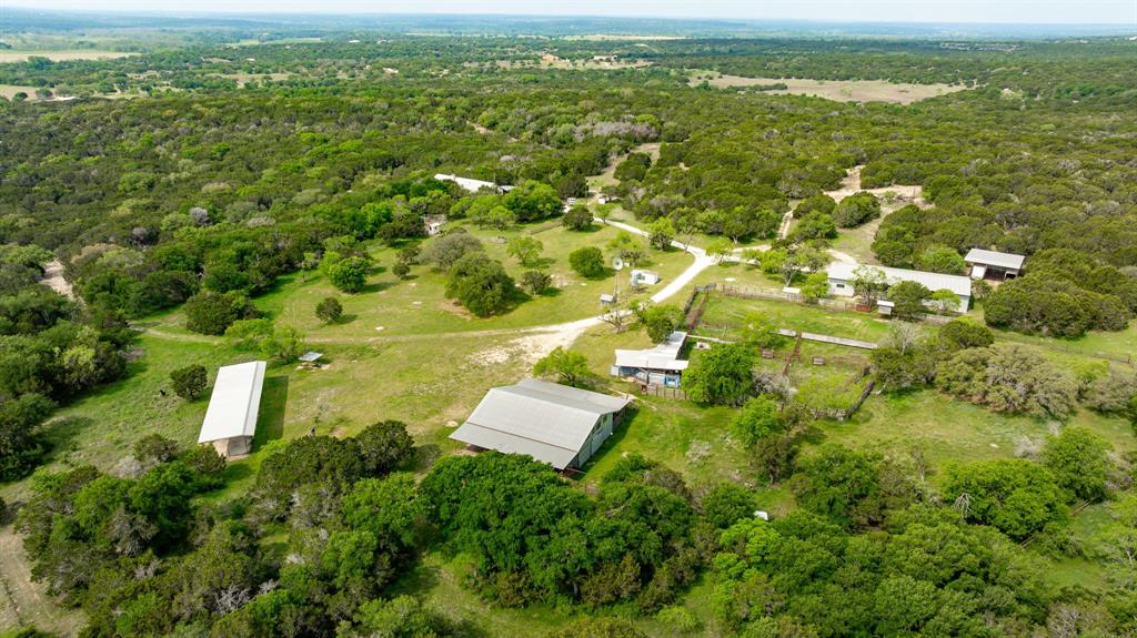 an aerial view of residential houses with outdoor space and trees