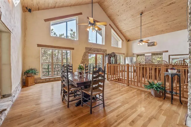 a dining hall with stainless steel appliances granite countertop a stove and wooden floors