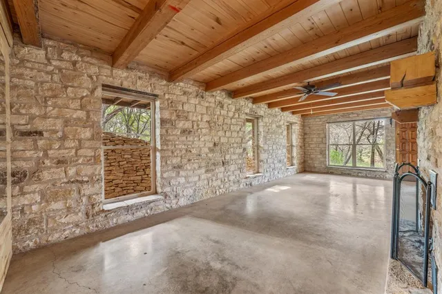 an empty room with fireplace and chandelier