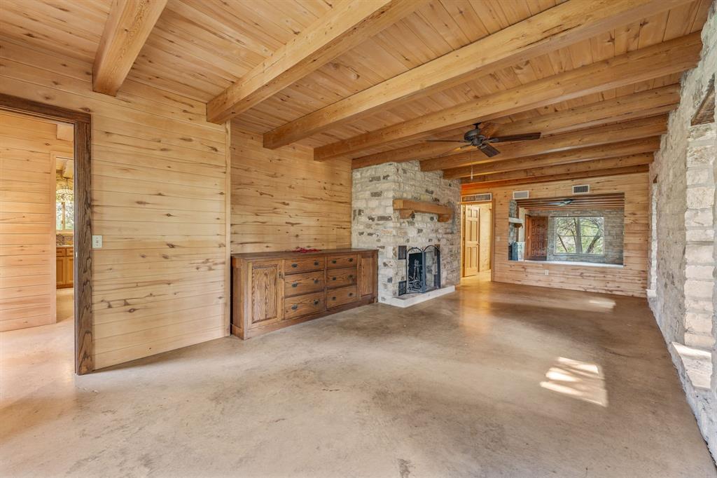 5905 North Us Highway Hamilton, TX 76531 - Photo 30 of 40 an empty room with fireplace and chandelier