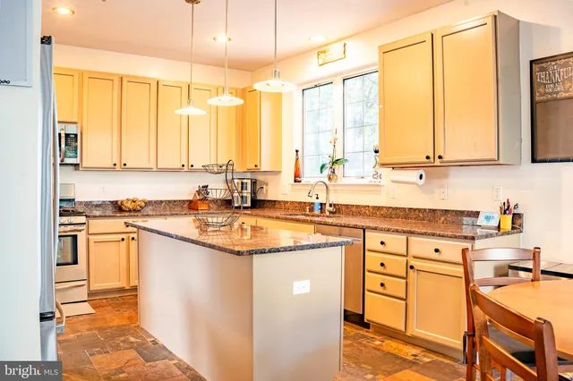 a kitchen with stainless steel appliances granite countertop a sink and a stove