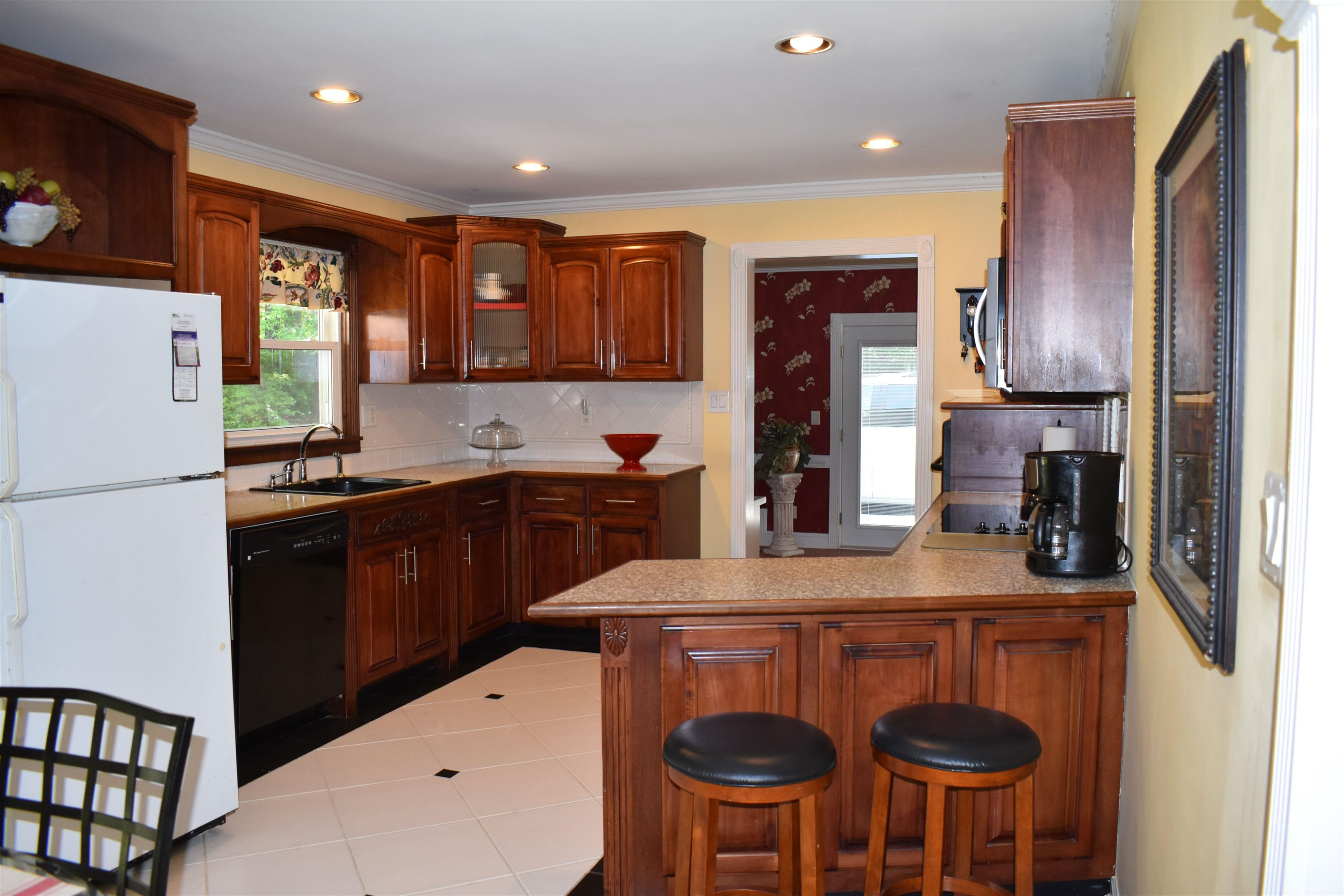 512 Grovemont Road Raleigh, NC 27603 - Photo 6 of 23 Kitchen w/ tile floor covering, custom counters, tile back splash, smooth top Frigidaire self cleaning oven, brand new range surface w/over the range is custom counter! dishwasher & new built-in microwave! Kitchen