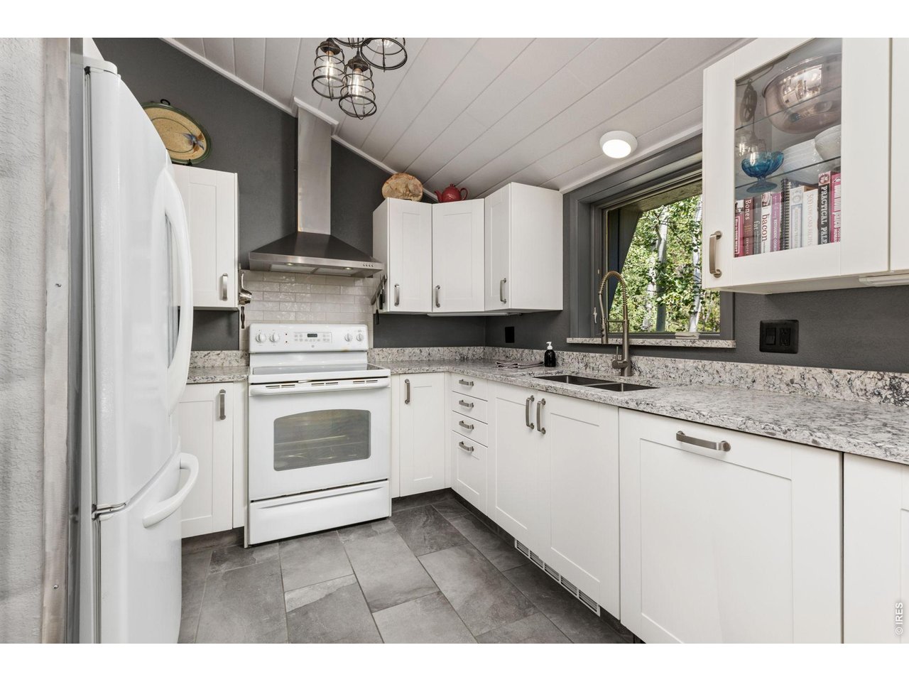 415 Upper Travis Gulch Road Black Hawk, CO 80422 - Photo 19 of 50 Remodeled kitchen (2017) features quartz counters, bright white cabinetry and updated appliances (dishwasher has a blended cabinet front-RHS of pic)