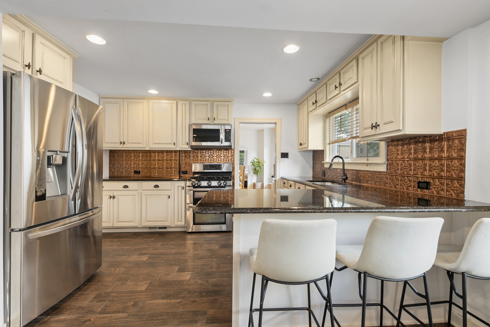 714 Walnut Street Lemont, IL 60439 - Photo 14 of 25 a kitchen with stainless steel appliances a sink a stove a refrigerator cabinets and a dining table with wooden floor