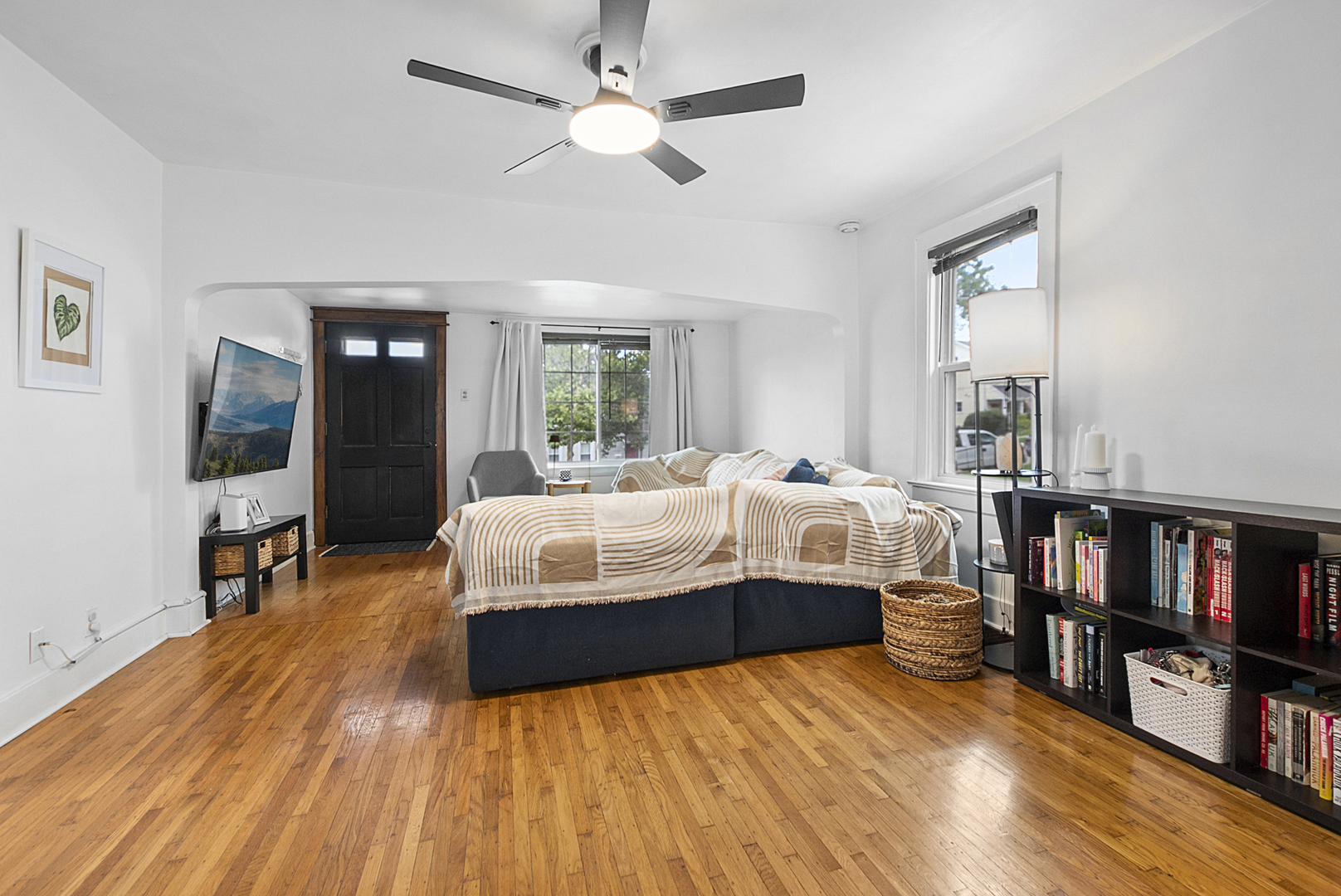 714 Walnut Street Lemont, IL 60439 - Photo 4 of 25 a bedroom with a large bed a flat tv screen and a book shelf