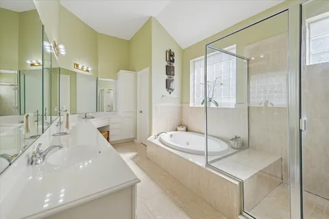 a bathroom with a tub a double vanity sink and mirror