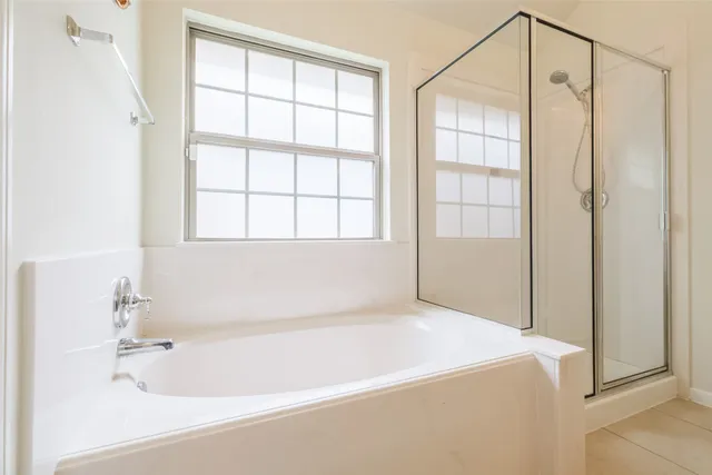 a spacious bathroom with a tub shower and sink