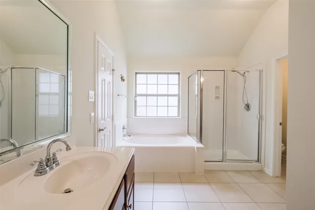 an empty room with windows and chandelier fan