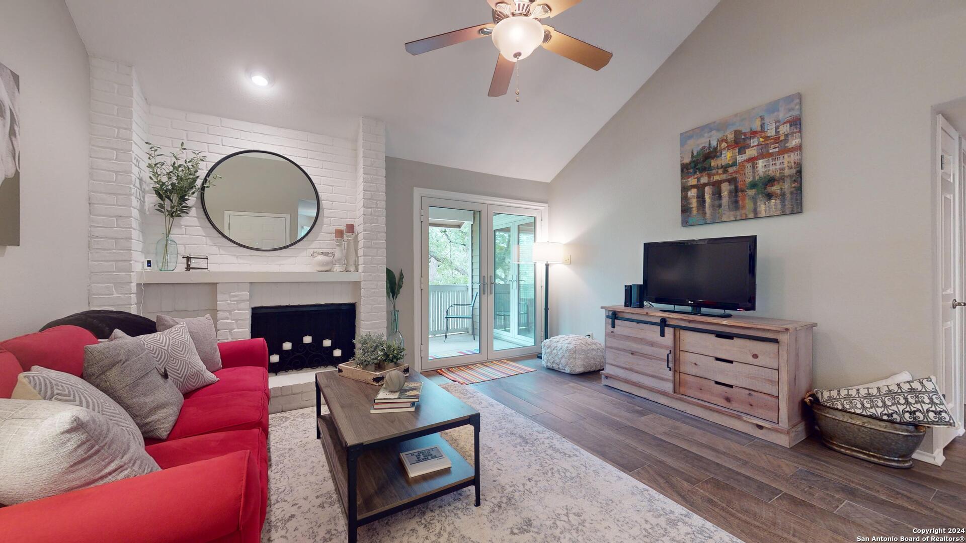 13130 Blanco Road, Unit 802 San Antonio, TX 78216 - Photo 1 of 1 a living room with furniture a flat screen tv and a fireplace