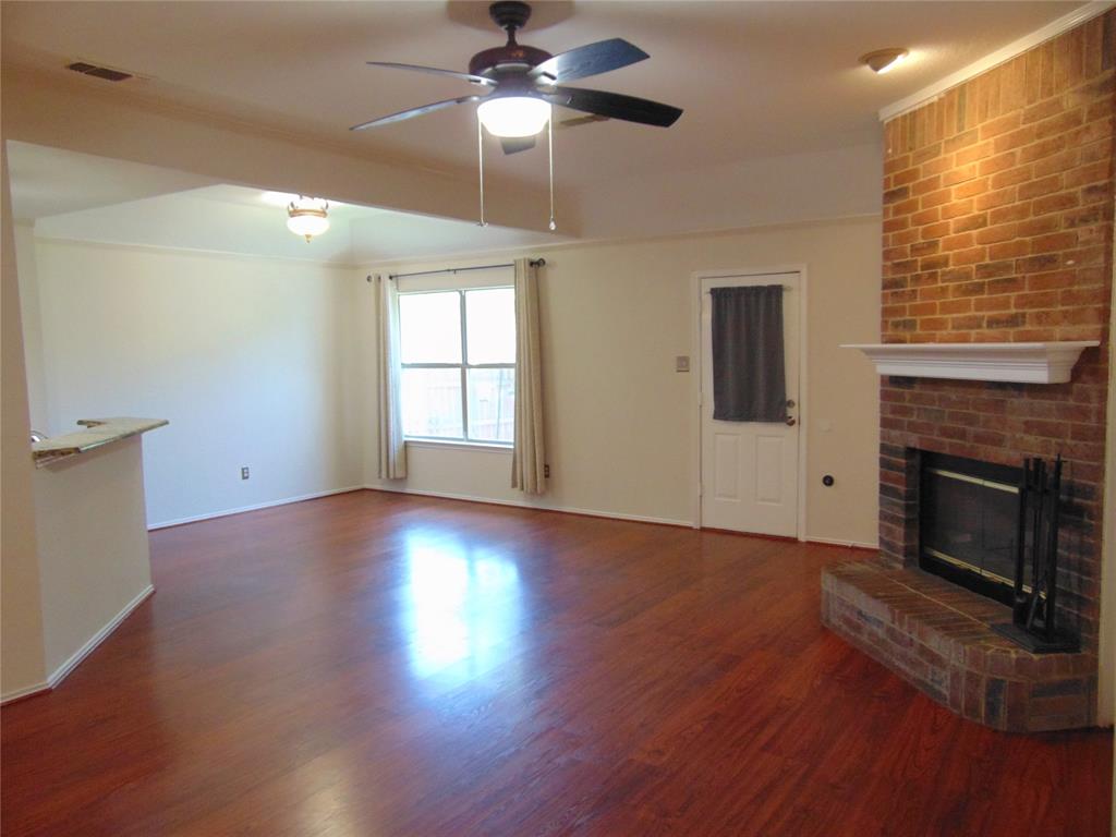 1425 Sunny Meadow Road Lancaster, TX 75134 - Photo 2 of 22 a view of an empty room with wooden floor fireplace and a window