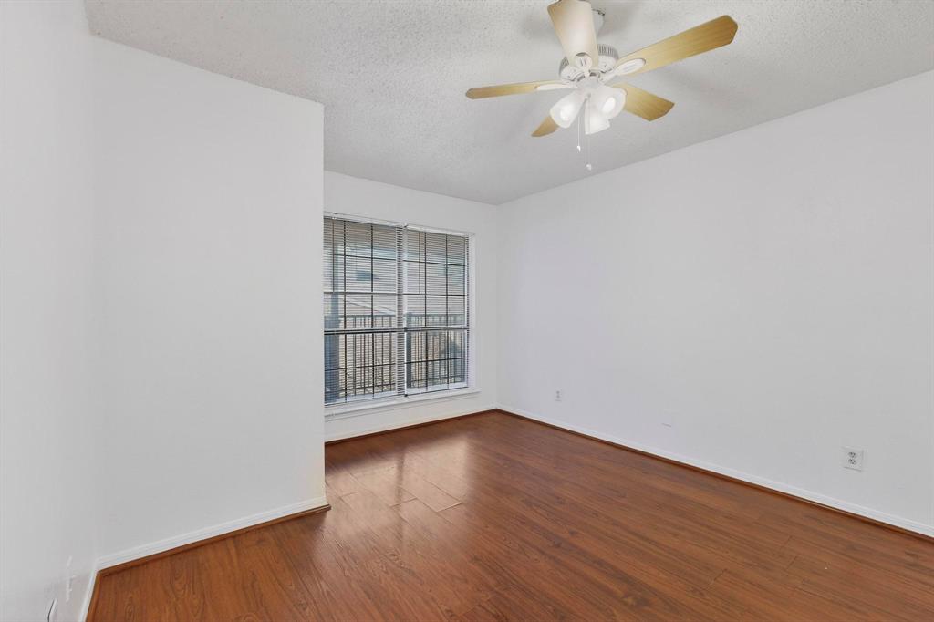 8545 Midpark Road, Unit 16 Dallas, TX 75240 - Photo 26 of 29 Spare room with dark wood finished floors, a ceiling fan, and a textured ceiling
