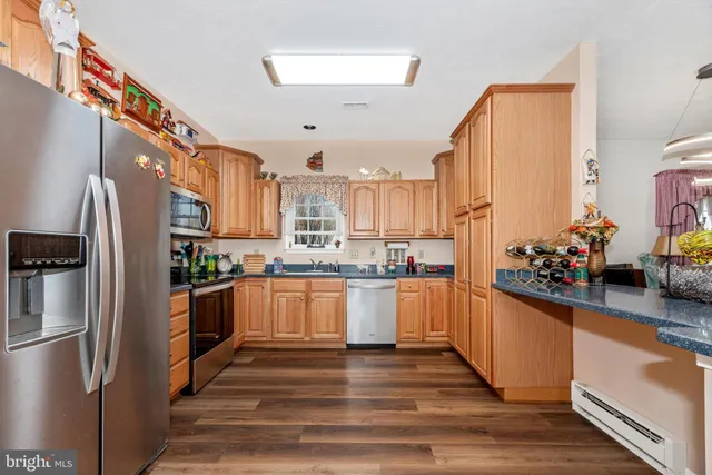 a kitchen with kitchen island granite countertop a sink cabinets and wooden floor