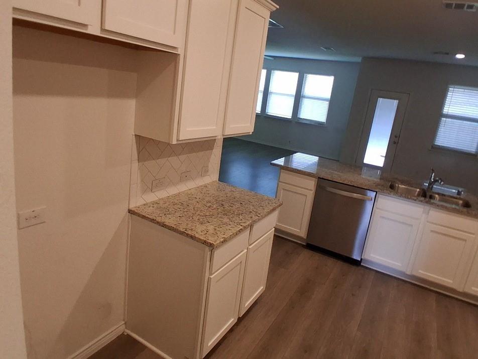 141 Colony Way Fate, TX 75189 - Photo 3 of 20 an empty room with wooden floor and cabinet
