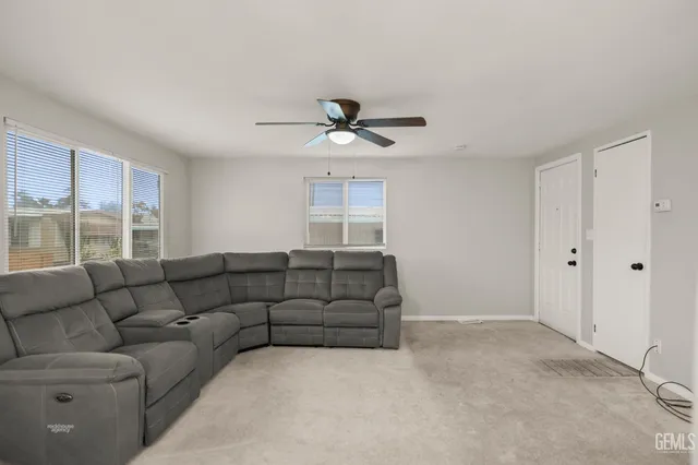 a living room with furniture and a ceiling fan