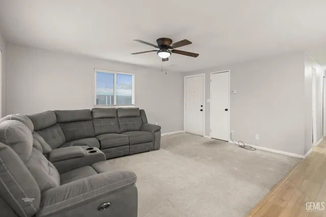 a living room with furniture and a ceiling fan