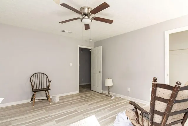 a view of a hallway with wooden floor and workspace