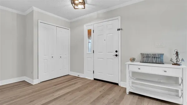 a view of an empty room with closet and wooden floor